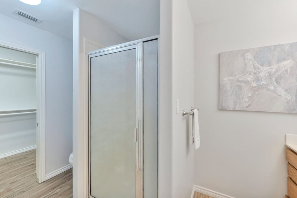 Step into your serene bathroom retreat with modern finishes, ocean-inspired artwork, and soft towels waiting for your arrival.