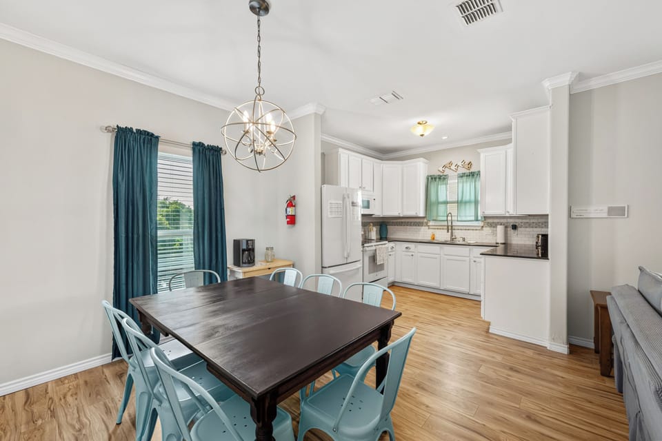 Gather around the spacious dining table for meals and memories, with a fully equipped kitchen at your fingertips and soft natural light streaming through elegant windows.