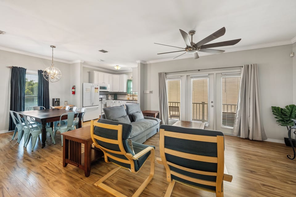 Settle into your open-concept living space where everything flows together—from the dining table to the cozy sofa and the full kitchen, all bathed in natural light from the balcony doors. Perfect for gathering with loved ones.