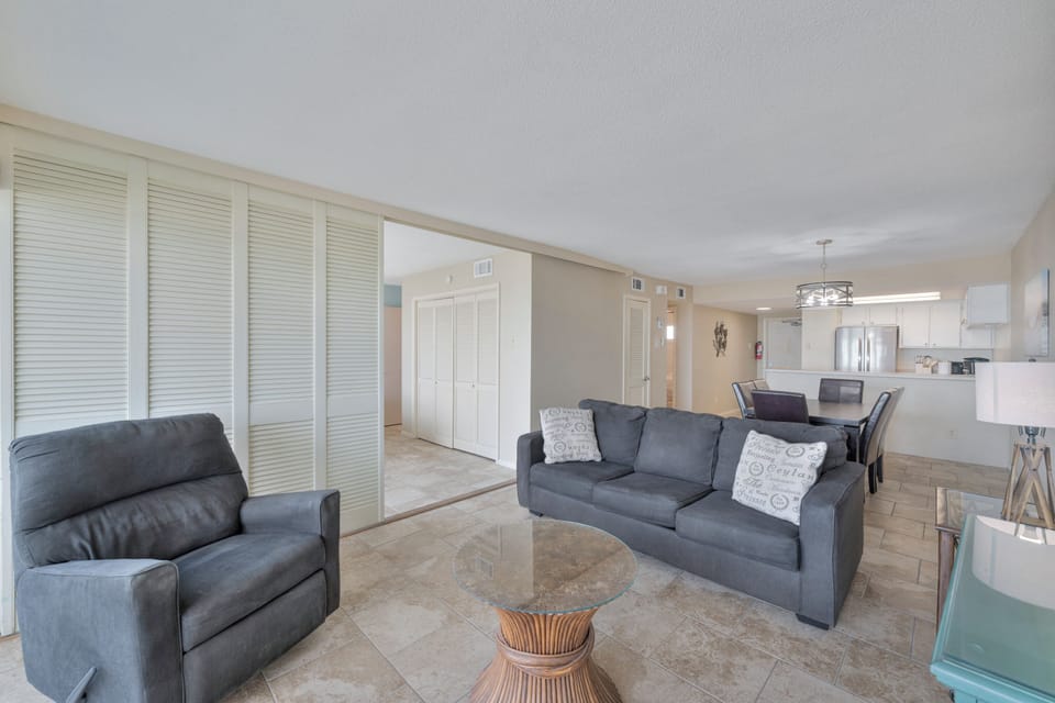 Unwind in your spacious open-plan living area with comfortable gray seating, elegant marble floors, and seamless flow to your modern kitchen.