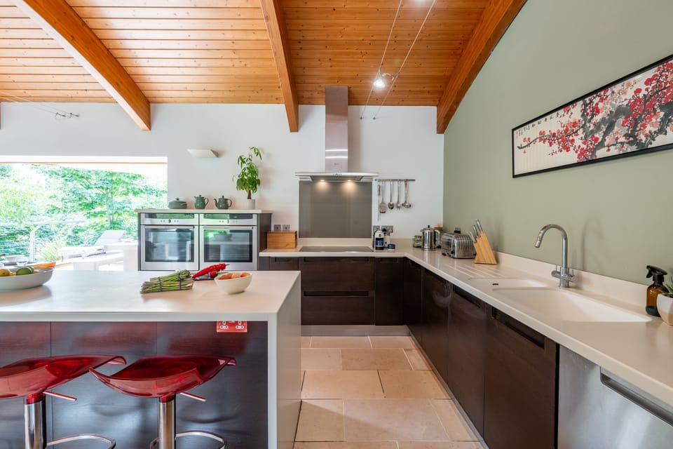 First floor: Kitchen area with double electric ovens and induction hob, microwave, fridge (with double sliding drawers), dishwasher, air fryer and Lavazzo coffee machine and sit up island with three stools
