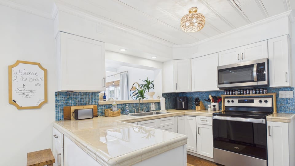 Fully applianced kitchen with breakfast bar seating at the counter and sink window
