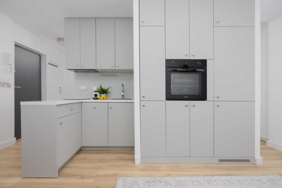 The tall kitchen cabinets provide generous storage, allowing guests to keep the apartment tidy and easy to use.