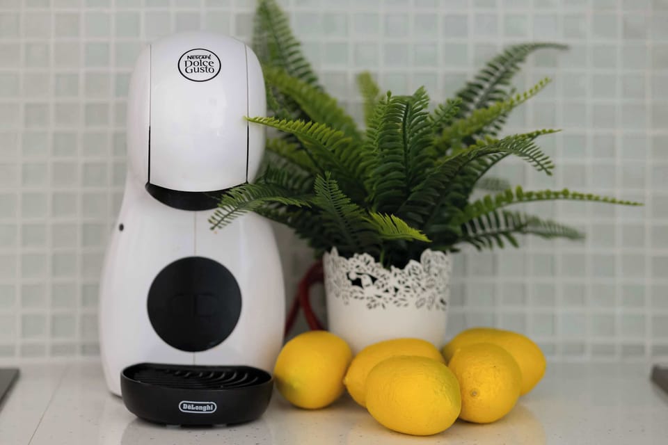 The countertop with a coffee machine and lemons adds freshness to the interior, creating a morning corner perfect for starting the day with aroma and energy.