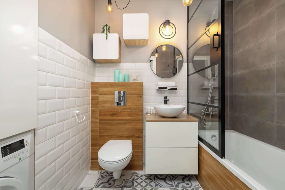 Another view of the bathroom showing the bathtub, toilet, and sink with wooden cabinetry. Modern fixtures create a stylish look.
