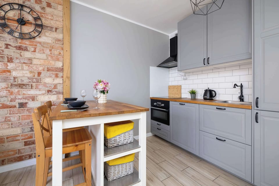 Another angle of the kitchenette with a small dining table and bar counter. Modern appliances are neatly arranged.