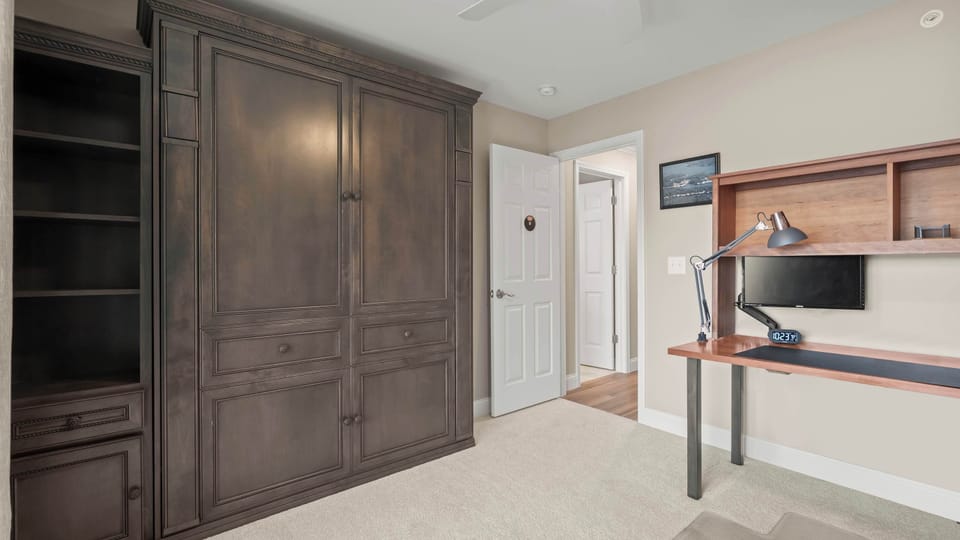 The final bedroom offers a desk workspace, smart TV, & queen Murphy bed​