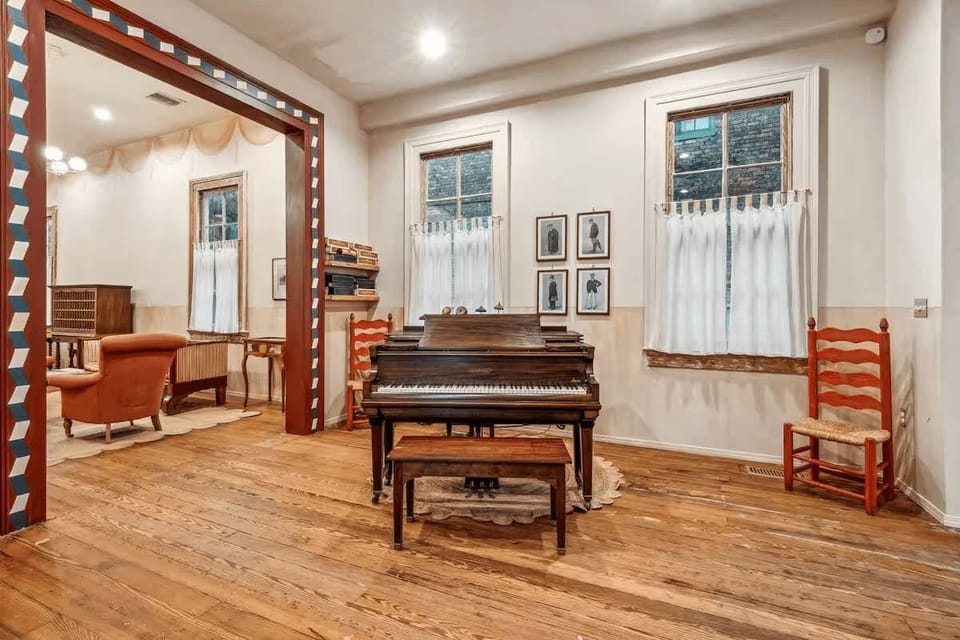 Piano lounge area with historic décor and original wood floors.