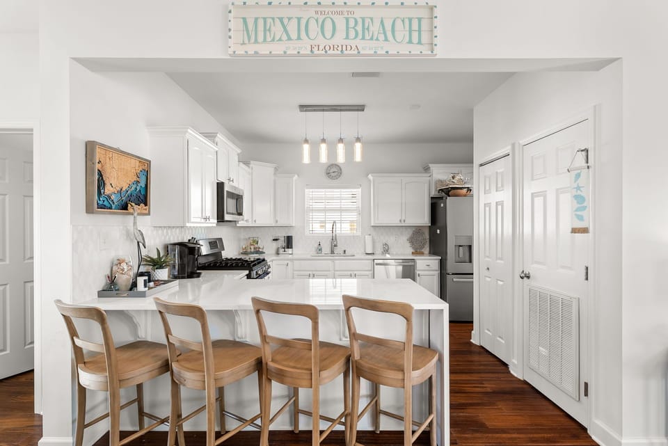 Your bright, fully-equipped kitchen welcomes you with white cabinetry, modern appliances, and a spacious island for gathering over morning coffee.