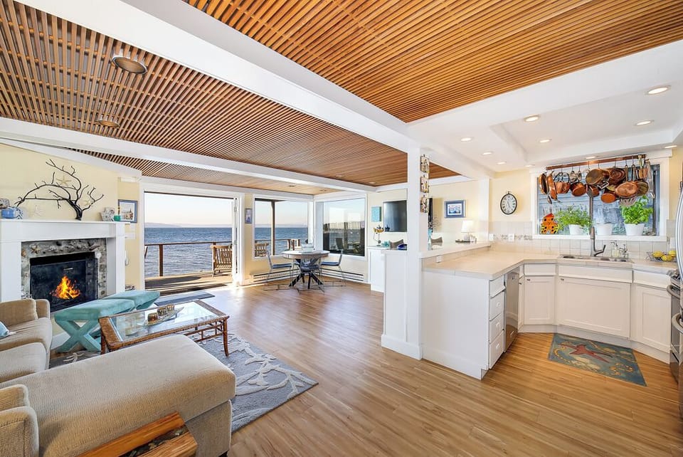 Beautiful living room with cozy gas fireplace, French doors opening to the deck