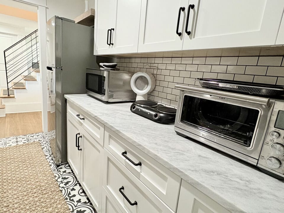 Kitchenette with air fryer, microwave, and two burner electric stove.