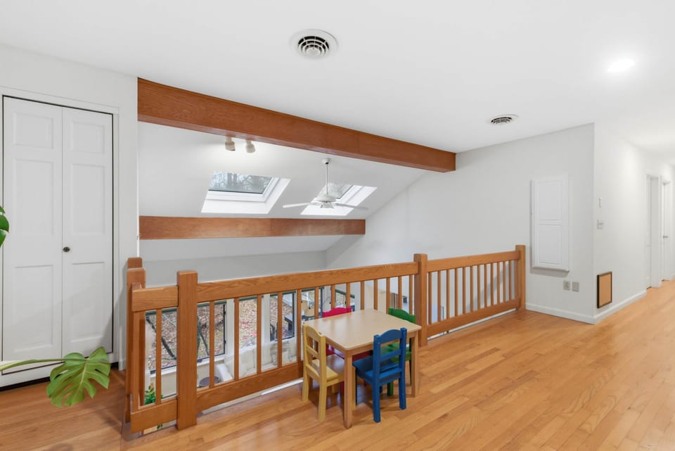 Open loft nook with skylights and kid-sized table—works well as a play area, craft station, or quiet corner away from the main level