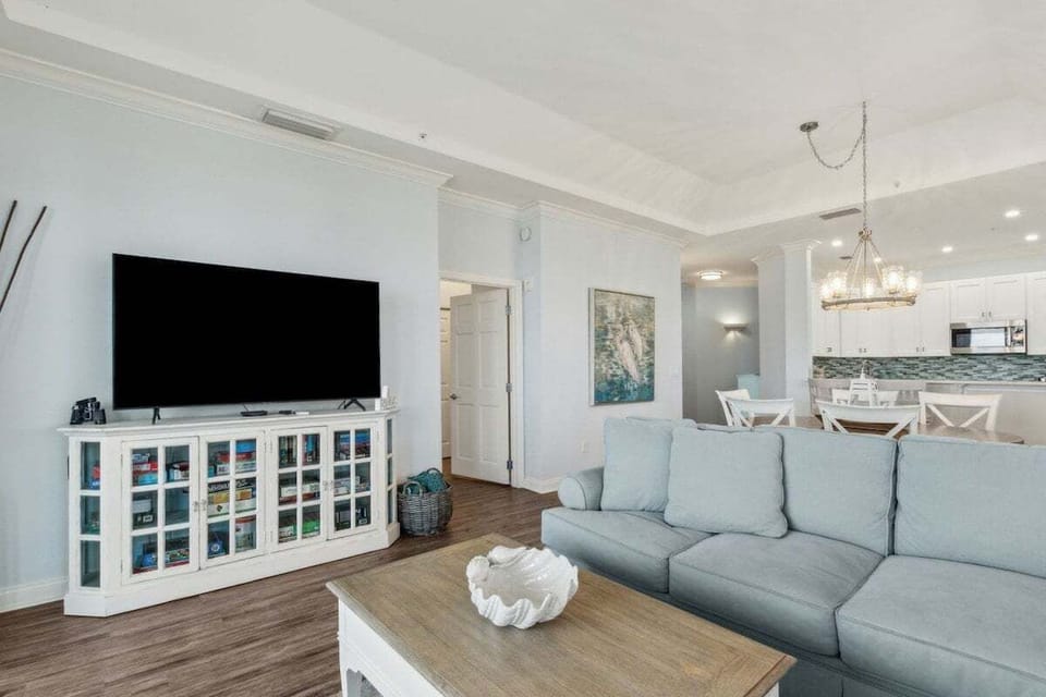 Spacious coastal living room with oversized flat-screen TV.
