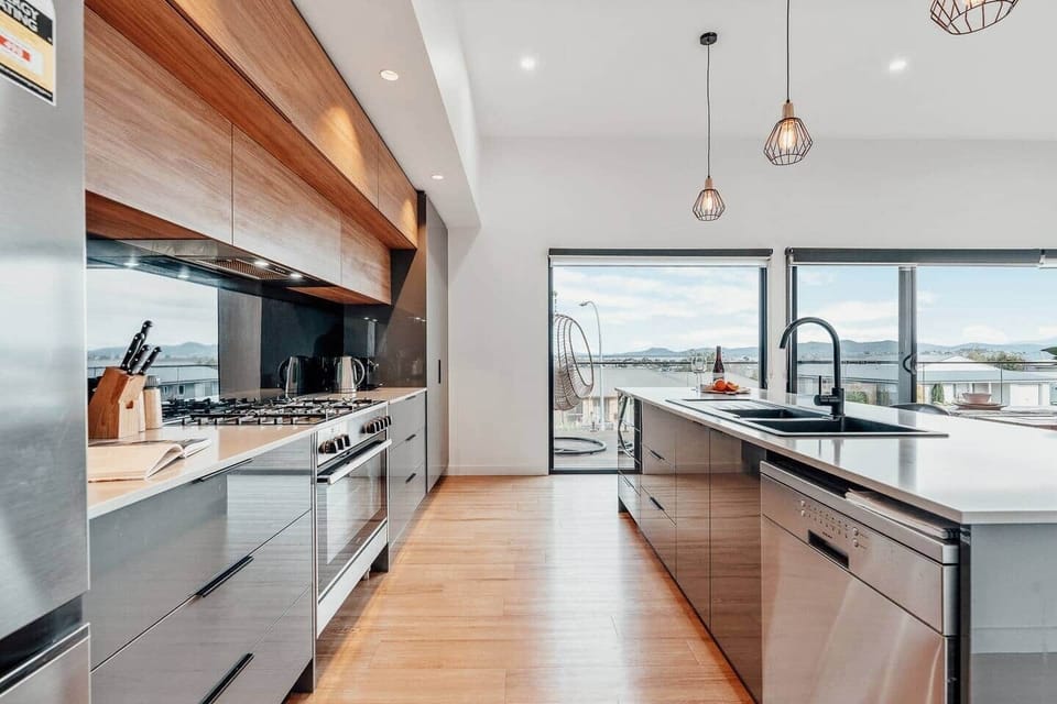 The scenic vistas of the water, landscape, and a five-mile beach, bathed in the warm glow of the sunset from dinning and kitchen area.