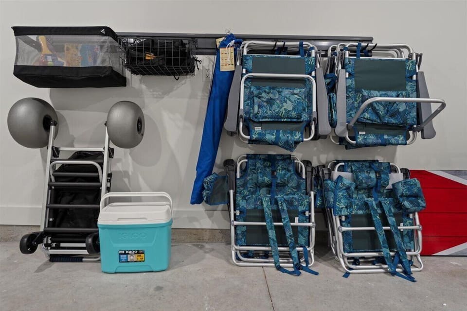 Fully stocked beach gear center including chairs, umbrellas, cooler, beach cart, and accessories for effortless trips to the shore.