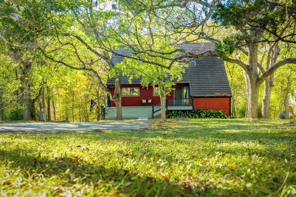 Charming A-frame style exterior nestled beneath a canopy of trees, offering privacy and natural beauty.