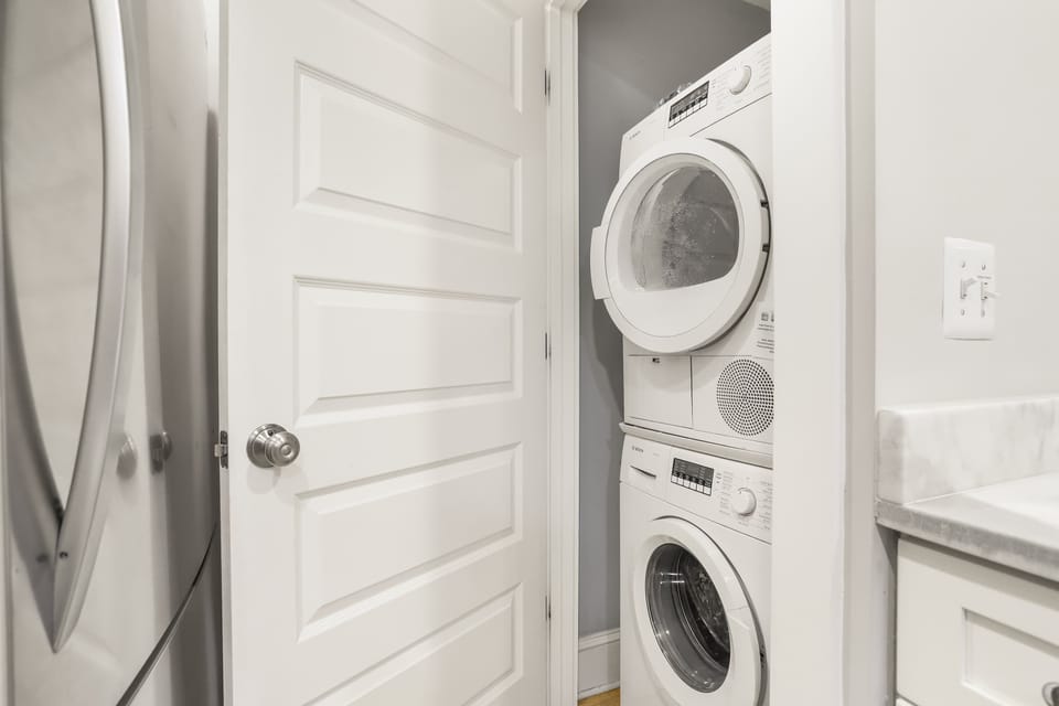 In unit washer & dryer located inside door beside kitchen counter