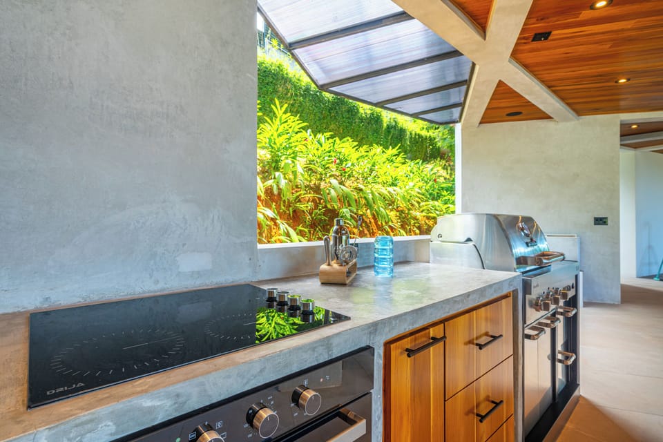 Outdoor full kitchen/BBQ, living room, half bath and yoga/exercise/weights area