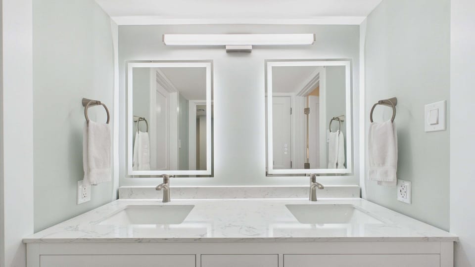 Master bathroom with dual vanity sinks and beautifully renovated walk in shower