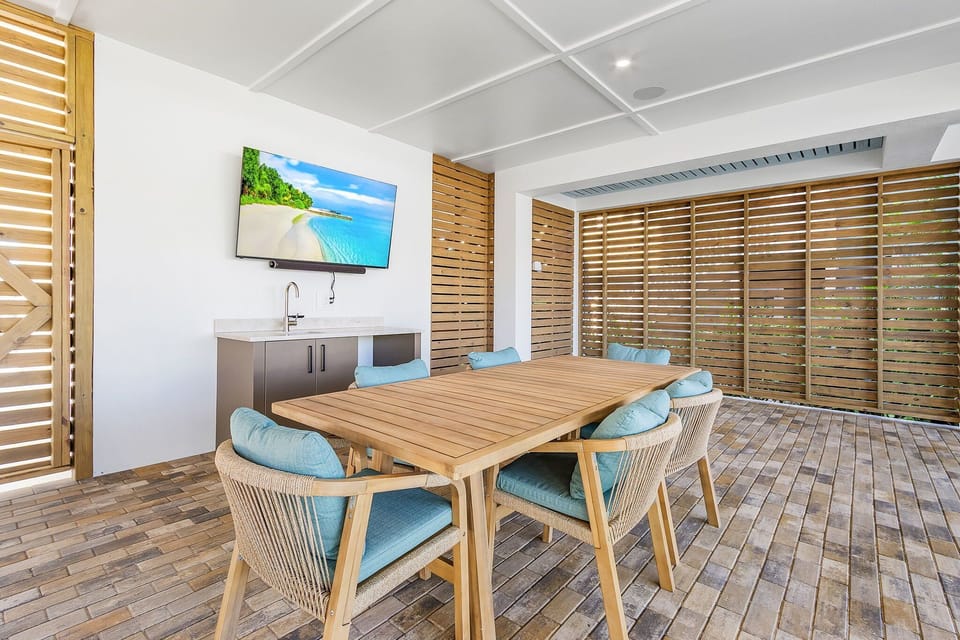 Pool patio includes a large TV, Sonos sound system, wet bar, and mini fridge