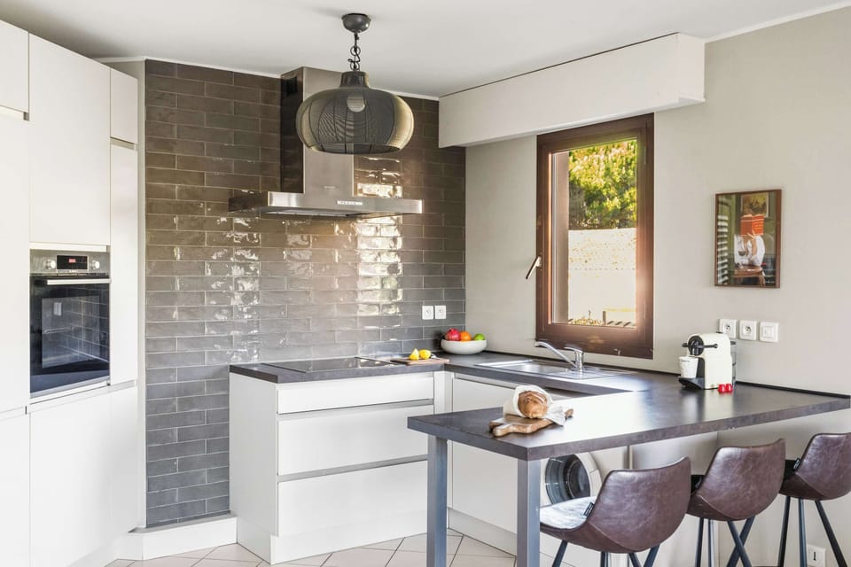Chef-ready kitchen with sleek finishes, modern appliances & a cozy dining nook perfect for shared meals or remote work