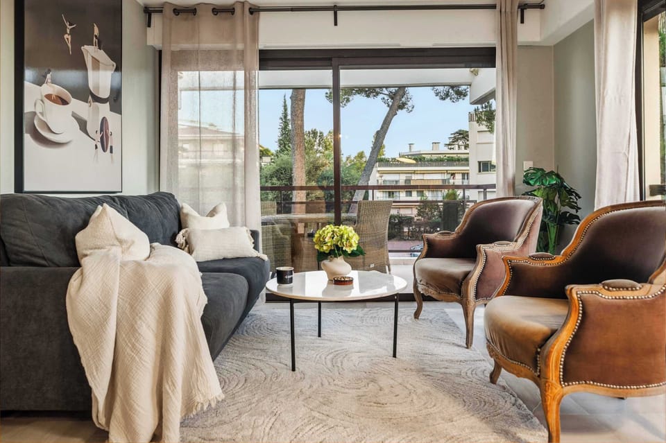 Spacious lounge framed by natural light and plush seating — designed for slow mornings and stylish evenings.