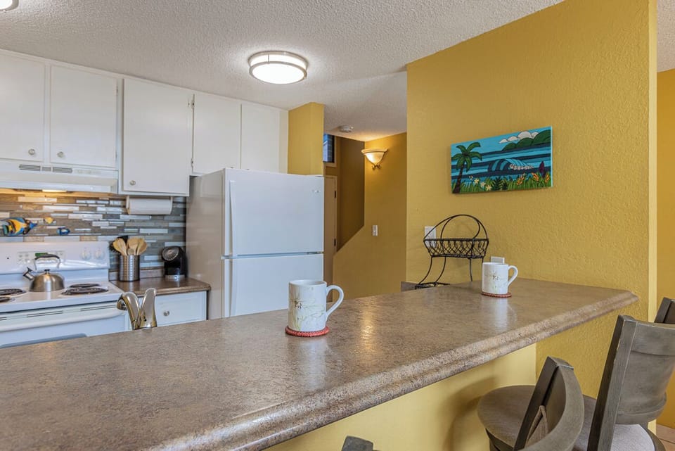 Your bright, sun-kissed kitchen welcomes you with warm yellow walls and a spacious breakfast bar—perfect for morning coffee or meal prep. Full appliances and cheerful details make it easy to feel at home.