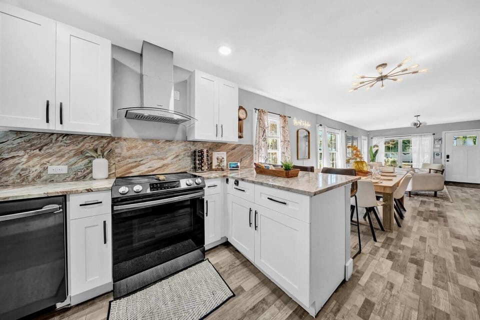 Large kitchen includes a stove, cooktop, dishwasher, spices, cookbooks, bar island, and all the kitchen accessories you will need.