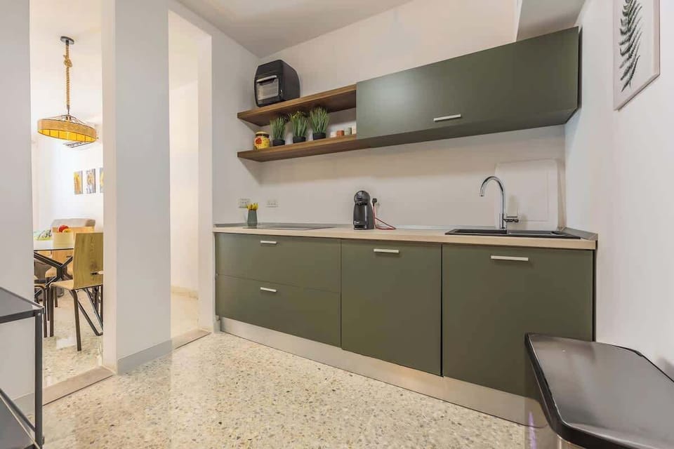 Modern kitchen with style – Matte olive green cabinetry, sleek countertops, and stainless steel fixtures make cooking a pleasure.