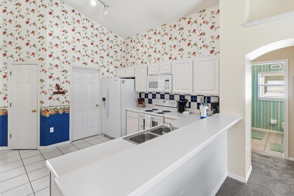 Bright, airy kitchen with charming vintage wallpaper and ample counter space