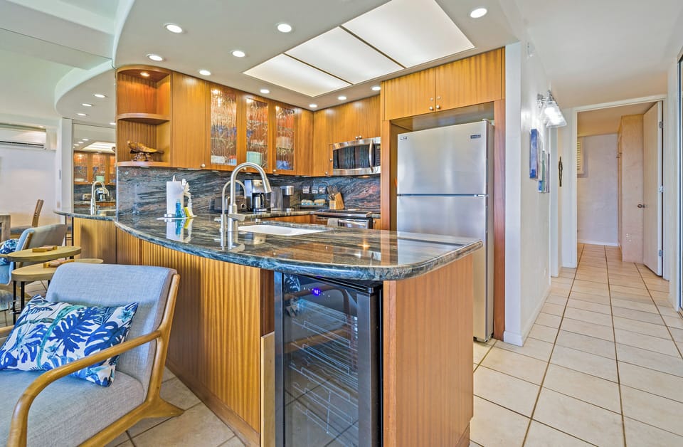 Modern chef's kitchen featuring a dedicated wine fridge and sleek stainless steel appliances.