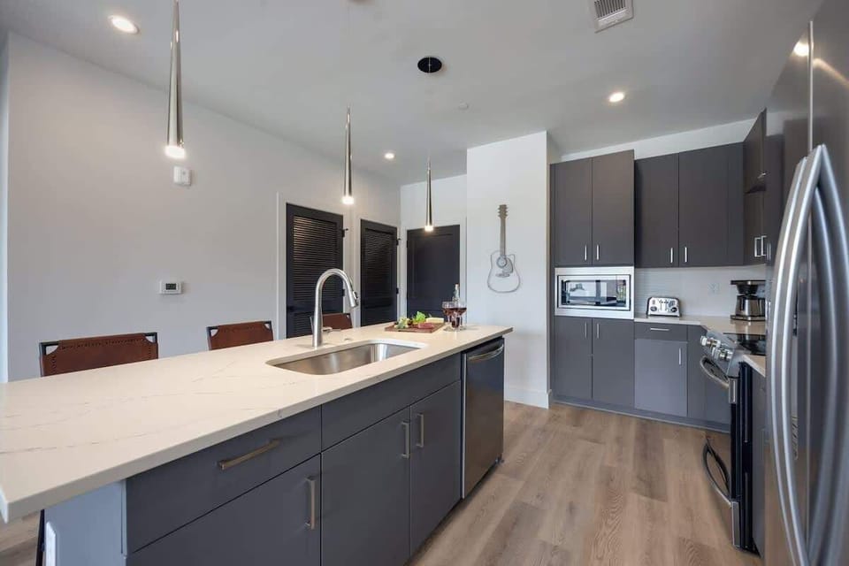 Unit 1: Fully equipped kitchen with brand-new stainless-steel appliances and a Kitchen island that offers ample counter space and bar seating.