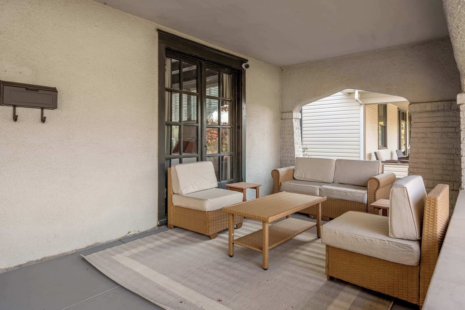 You'll find the quiet corner seat here with a book while the rest of the group is still asleep — this porch nook is made for the early hour before everyone's up.