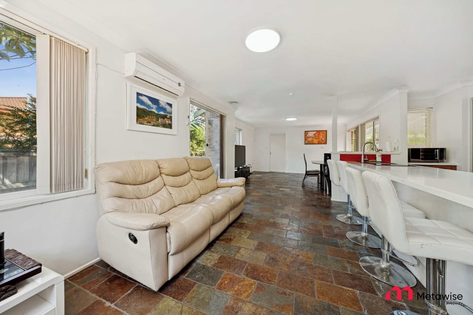Open-plan living space with cream sofa and adjoining kitchen area