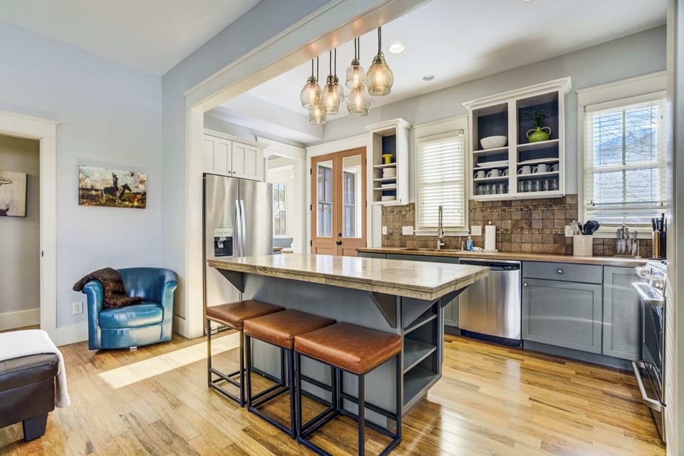 The open kitchen is designed for easy cooking with stainless appliances, generous counter space, and a large central island with seating. Nearby, the breakfast nook and casual seating create a warm, connected space for gathering throughout the day.