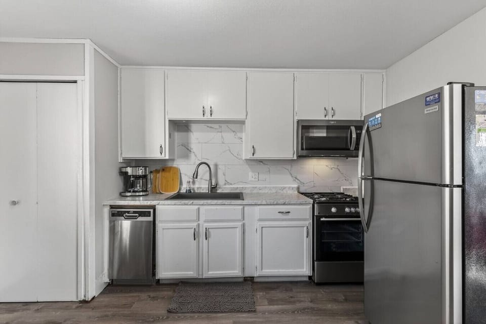 Bright, fully equipped kitchen with stainless steel appliances, quartz-style counters, and crisp white cabinetry. Includes dishwasher, microwave, coffee maker, and full-size fridge…perfect for cooking at home or quick meals on the go.