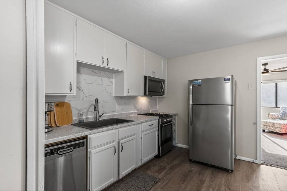 Bright, fully equipped kitchen with stainless steel appliances, quartz-style counters, and crisp white cabinetry. Includes dishwasher, microwave, coffee maker, and full-size fridge…perfect for cooking at home or quick meals on the go.