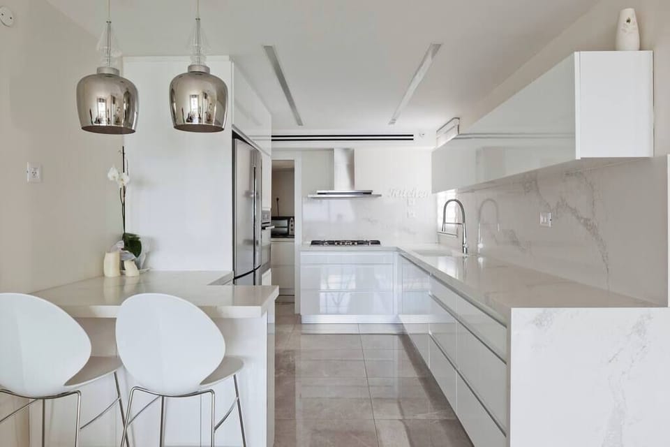 Modern kitchen includes bar seating, ideal for meals before heading to nearby restaurants and cafes.