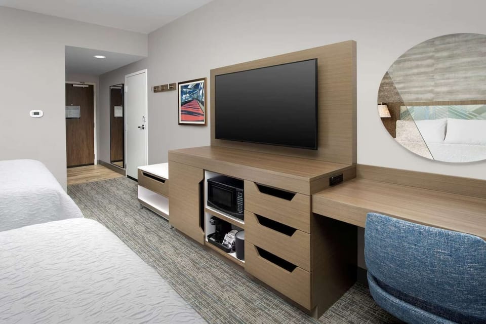Room with flat-screen TV, work desk, microwave, and coffee maker