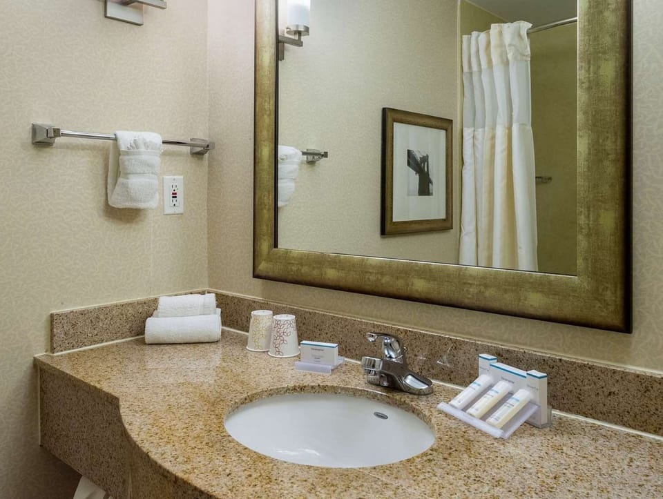 Bathroom sink with mirror, towels, and simple toiletries