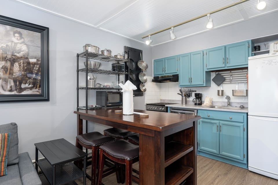 Your fully equipped kitchen features charming blue cabinets, modern appliances, and a spacious island where you can prep meals or enjoy casual dining together.