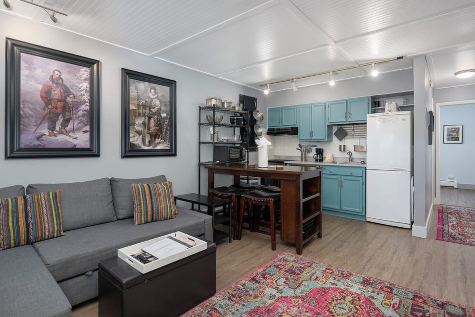 Your cozy open-plan suite blends comfort with functionality, featuring a plush sofa and fully equipped kitchen for memorable stays.
