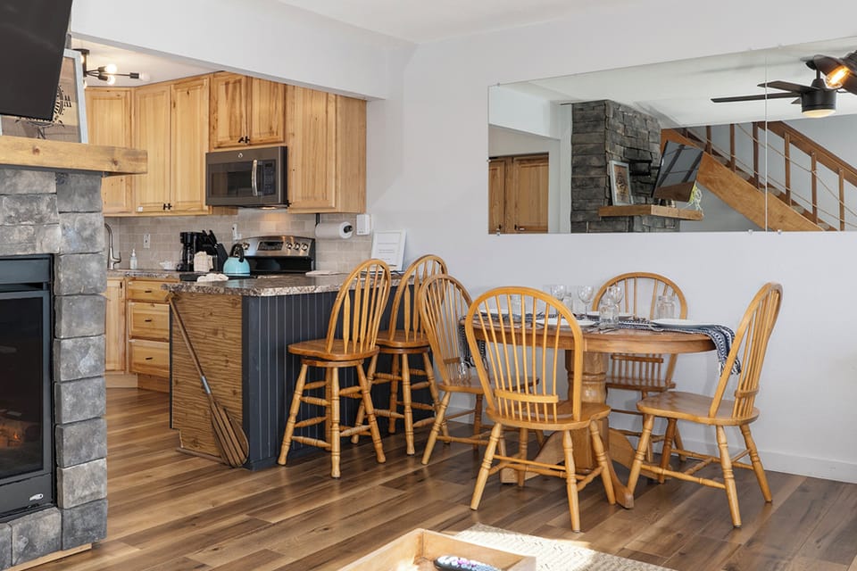 Your open kitchen flows into the dining area, in our Soda Springs Ranch condo 3C where rustic charm meets modern convenience with warm wood tones throughout.