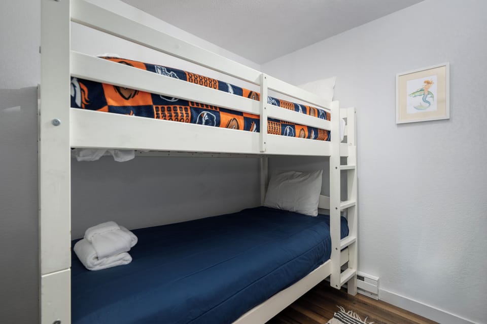 Your kids will love this cozy bunk bed setup at Soda Springs Ranch condo 3C with soft linens and cheerful sports-themed bedding for memorable sleepovers.