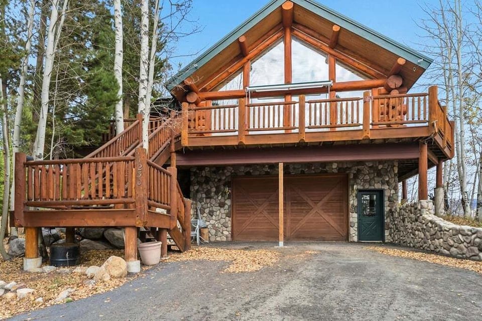 Beautiful mountain cabin surrounded by towering trees offers a perfect woodland retreat with stone details and spacious deck.