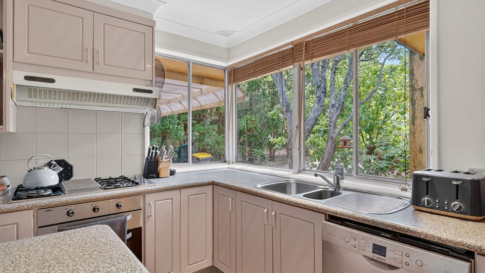 Functional kitchen with great natural light and garden outlook.