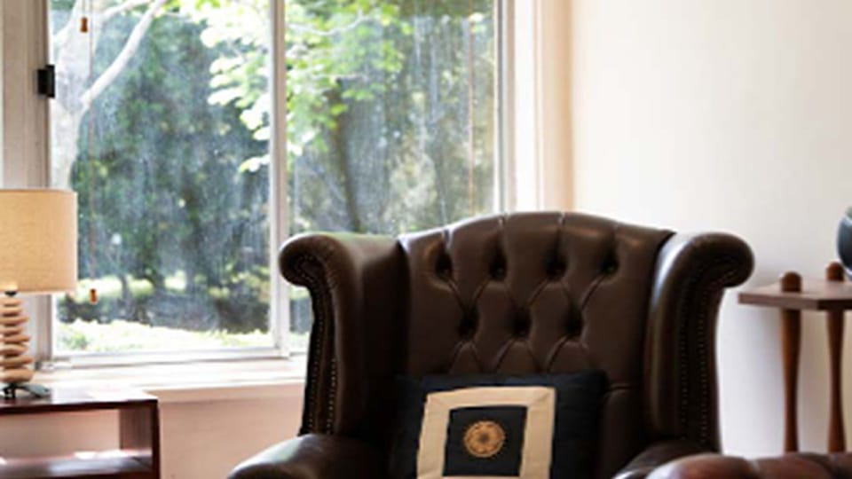 Cozy reading corner with an armchair and window view.