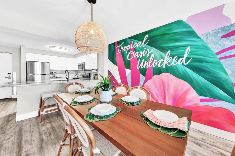 Dine surrounded by vibrant tropical murals in your modern open kitchen and dining space, perfectly set for memorable meals.
