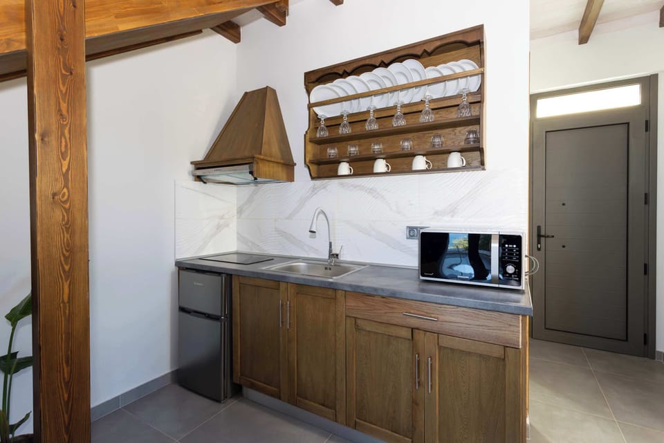 Fully Equipped Kitchenette with Wooden Cabinetry and Dining Counter
Practical cooking area featuring solid wood cupboards, stove, fridge, and all necessary appliances for preparing meals at home.