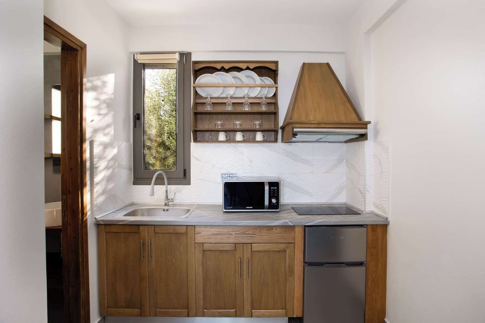 Fully Equipped Kitchenette with Wooden Cabinetry
Compact cooking space with stove, fridge, and storage for convenient meal prep.